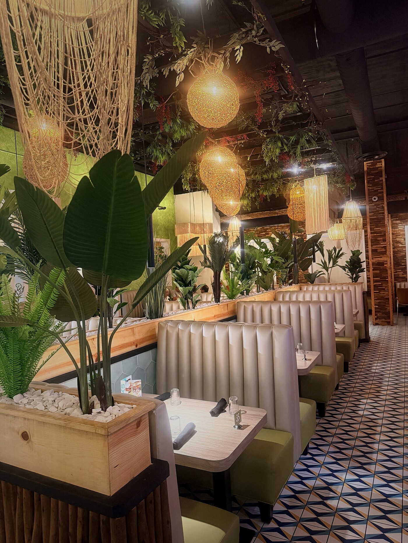 Interior con booths, plantas y lámparas tejidas — proyecto instalado
